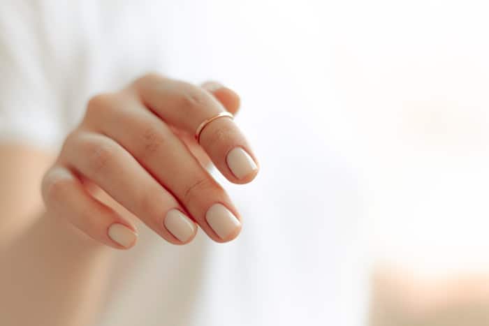 persons hand with white manicure