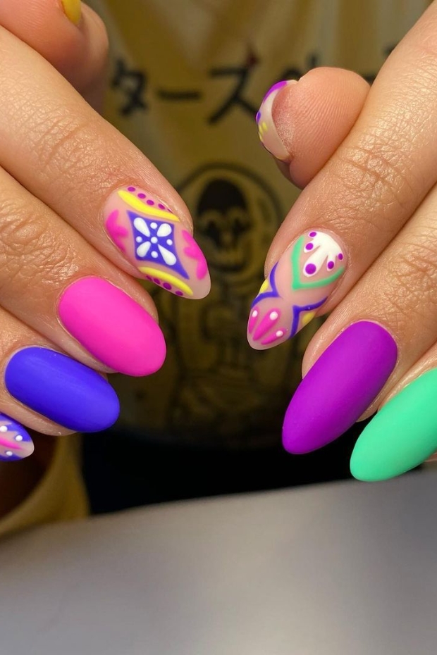Close-up photo of abstract almond nails showcasing vibrant colors and unique geometric patterns