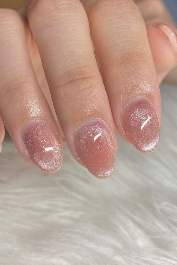Close-up of elegantly shaped almond nails painted in a classic, timeless shade, showcasing sophistication and style