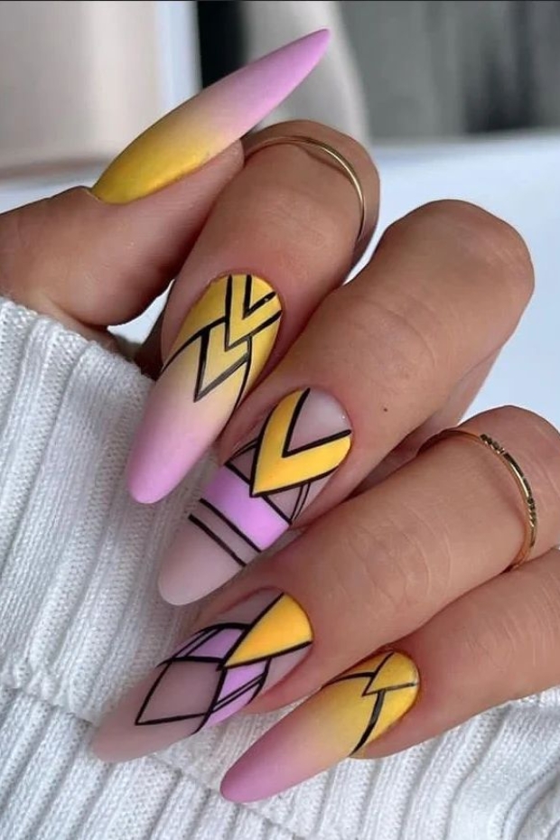 Close-up photo of perfectly shaped almond nails with geometric designs painted on them in vibrant colors