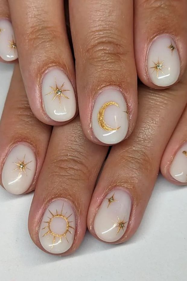 Gleaming with celestial vibes, these golden sun and moon nails are truly out of this world