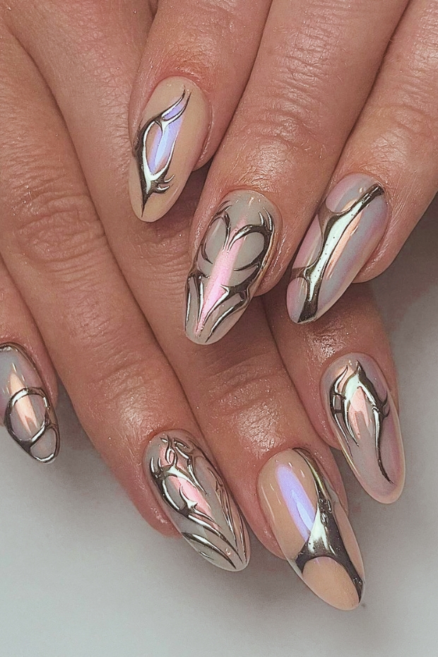 Close-up of manicured hands showcasing glittering and metallic almond-shaped nails with a glamorous and eye-catching design