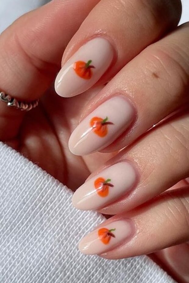 Orange and white pumpkin-themed nail art