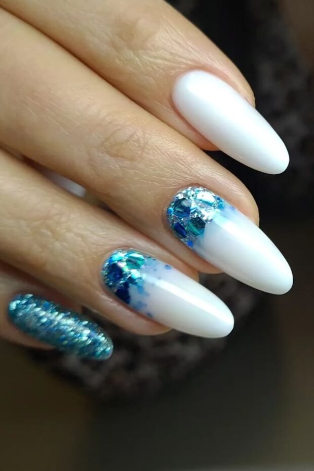 White almond nail with blue glitter pattern