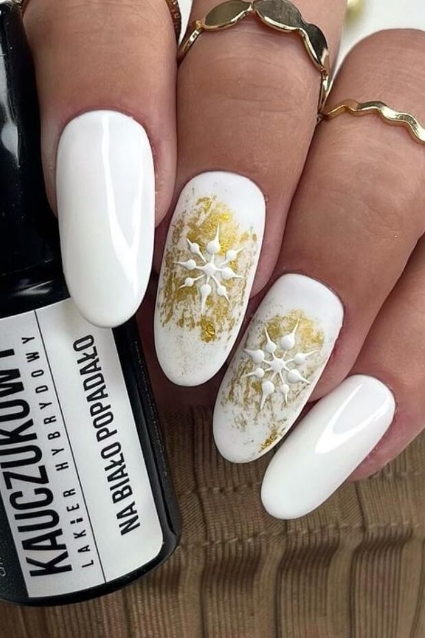 White nail art with gold leaf pattern