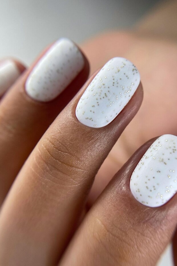 White nails with gold glitter accent