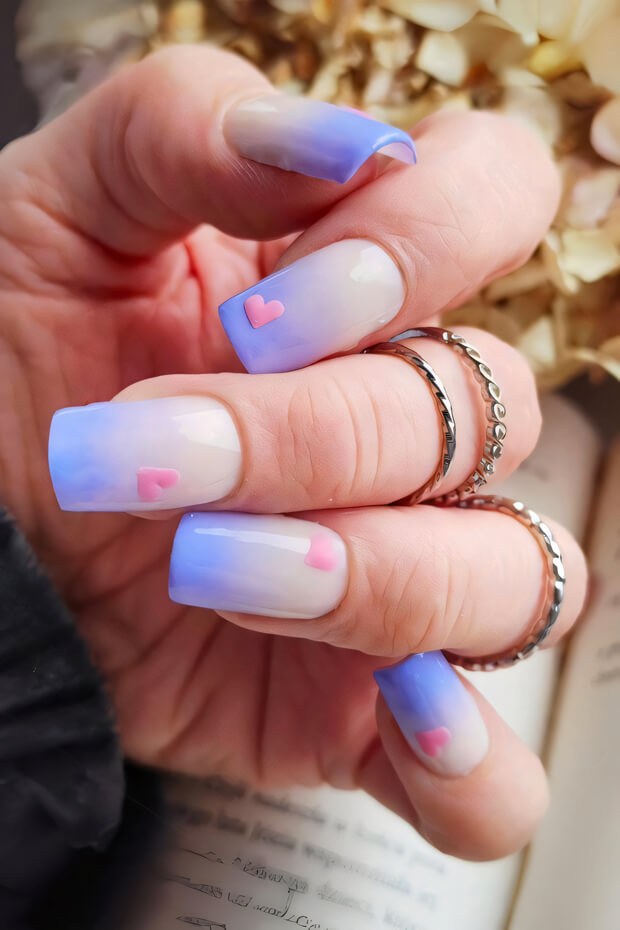 Heart-shaped accents on blue and pink nails