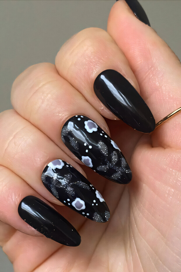 Black stiletto nail with intricate white floral design