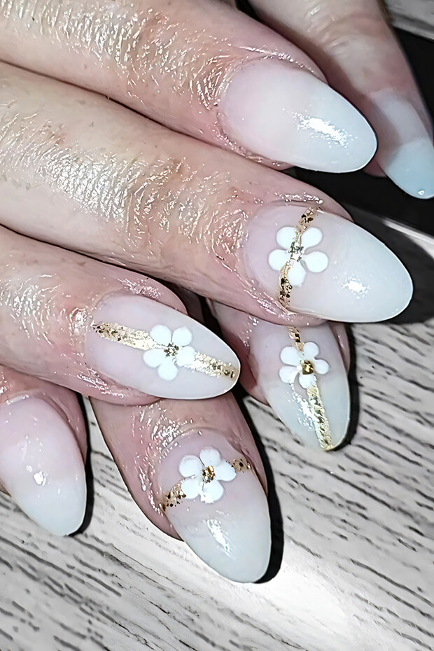 White flower with gold accents nail art design