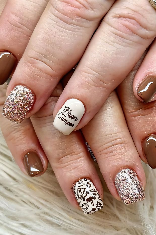Camping-themed nails design featuring camper motifs and earthy tones with glitter for outdoor enthusiasts.