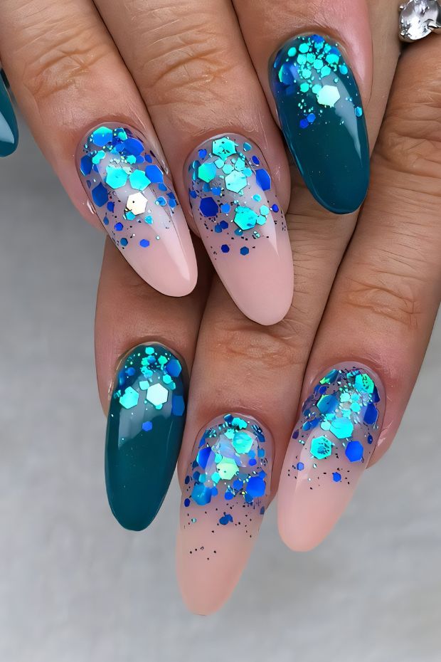 Nail art design with teal and nude shades, topped with glitter for a striking ombre effect.
