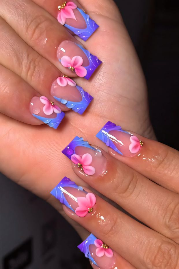 Beautiful floral nail designs with pink flowers on blue gradient nails with gold accents to inspire nail art lovers.