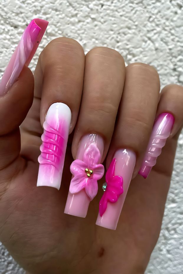 Bright pink nail art with 3D floral and textured designs for a unique nail look.