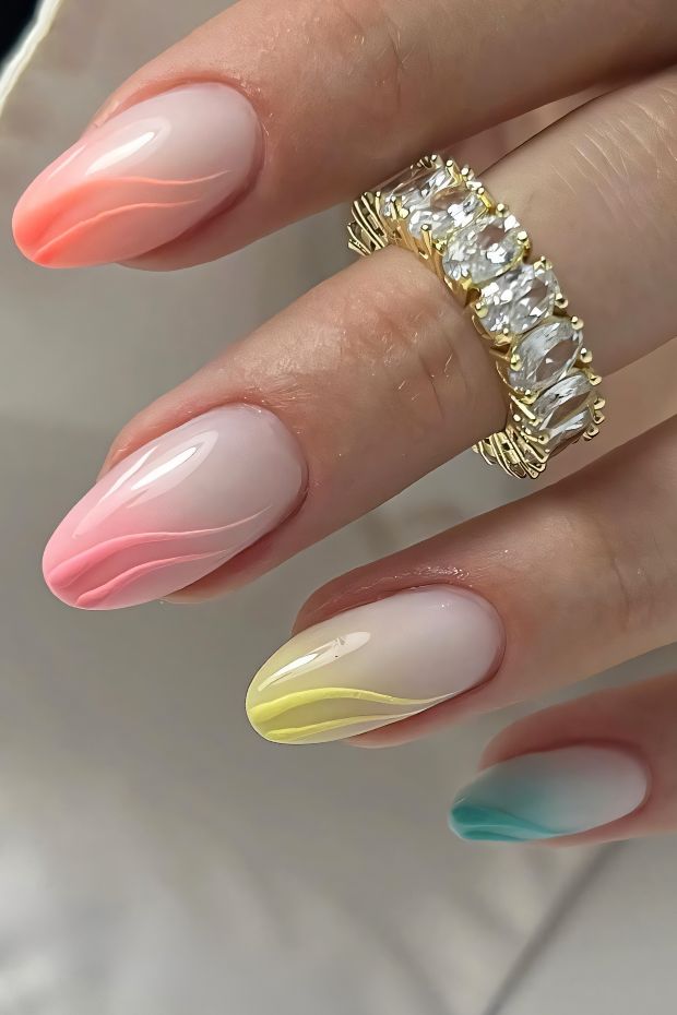 Colorful ombre nail design with swirling accents in pastel shades of pink, yellow, and blue for a creative look.