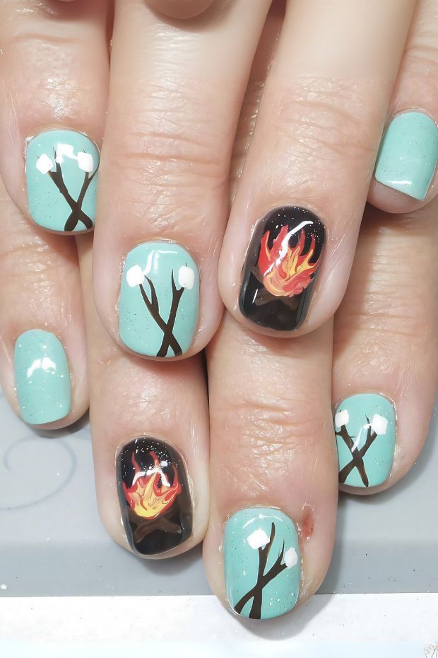Camping nails featuring marshmallow and campfire designs with mint green and black colors for nature lovers.