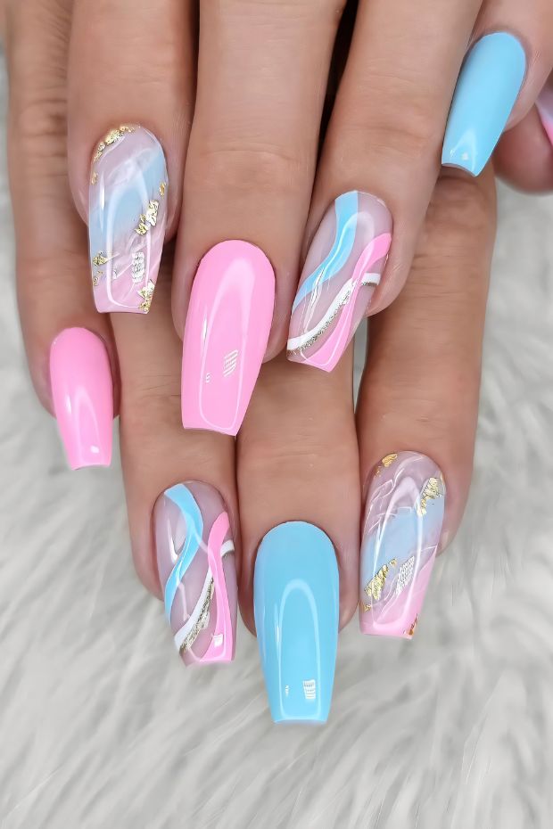 Vibrant pink and blue nail designs with gold accents featuring artistic swirls and glossy finish for trendy look.