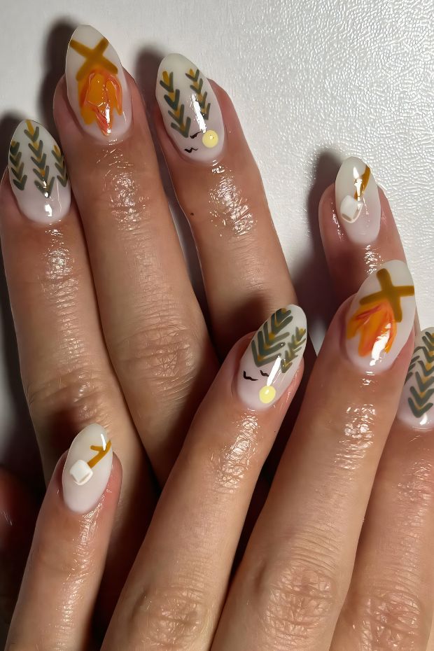 Camping nails with trees, campfire, and nature elements in earthy colors for adventurous nail art.