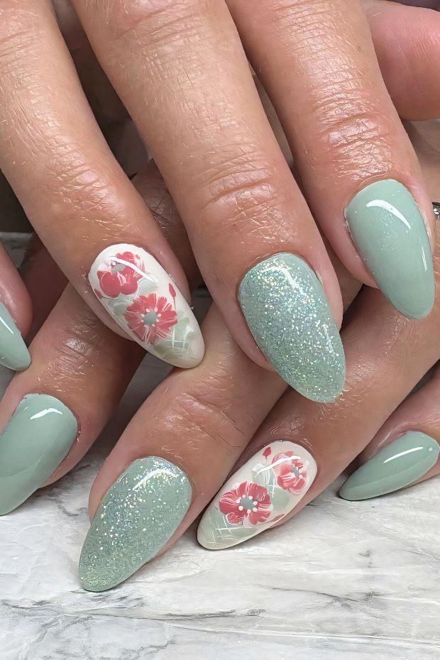 Mint green nails with glitter and floral accents create a charming and colorful nail art design.