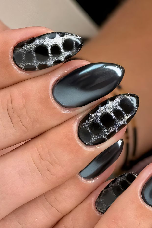 Black nail design featuring textured patterns and glossy finish for a bold and fashionable look.