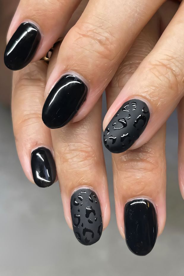 Black nails with leopard print texture for a bold, stylish nail design.