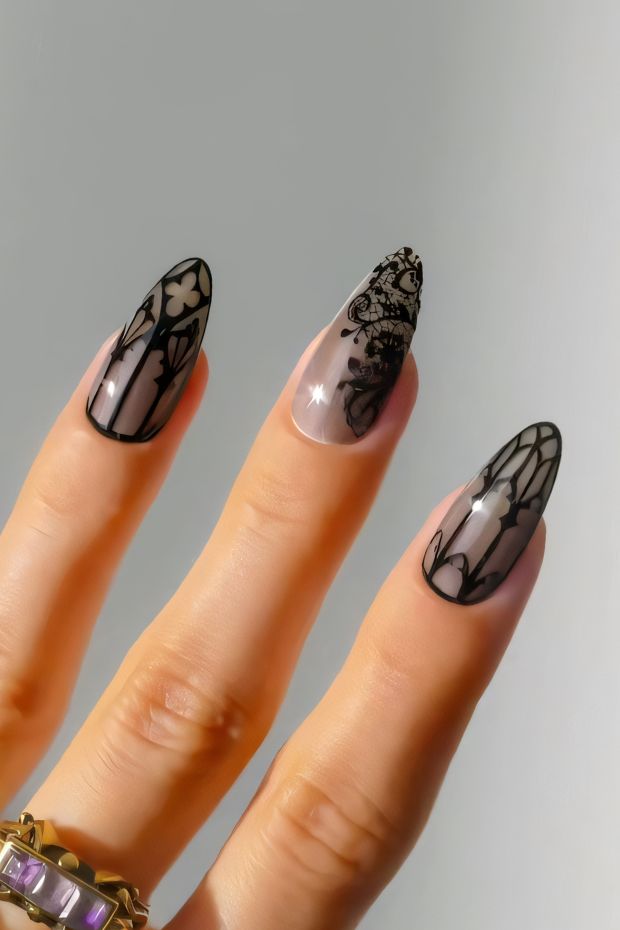 Black nail design with floral patterns and sheer accents, showcasing a dramatic and stylish look.