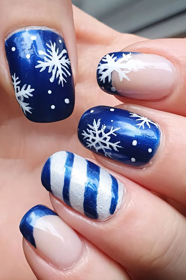 Winter nail design featuring snowflakes and blue stripes for a festive seasonal look.