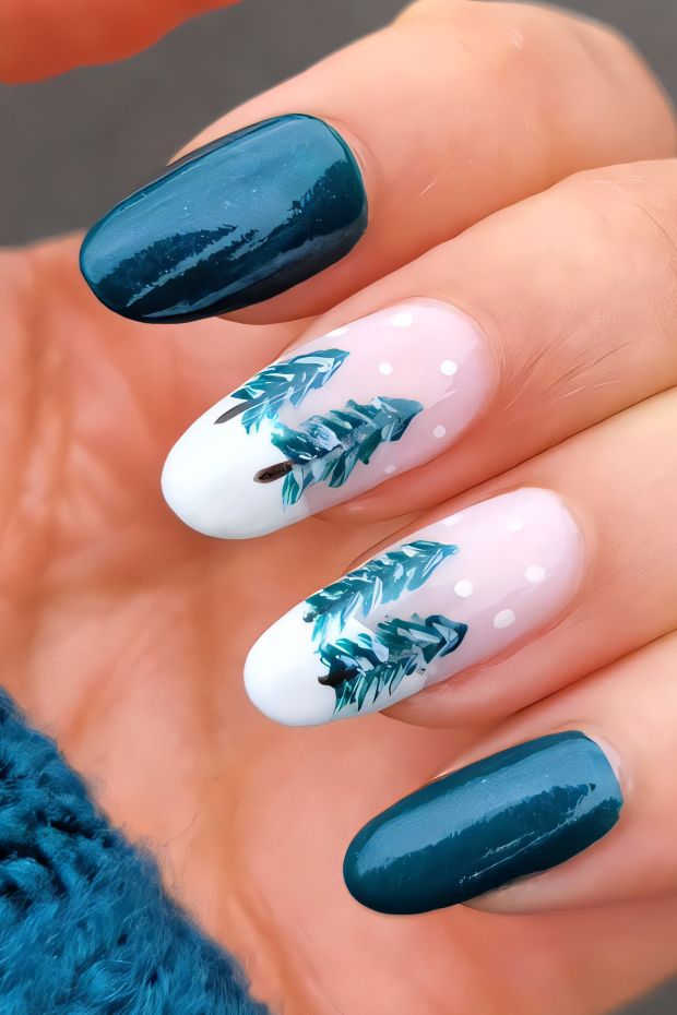 Winter nail art design with teal and white colors featuring pine trees and winter-themed details.
