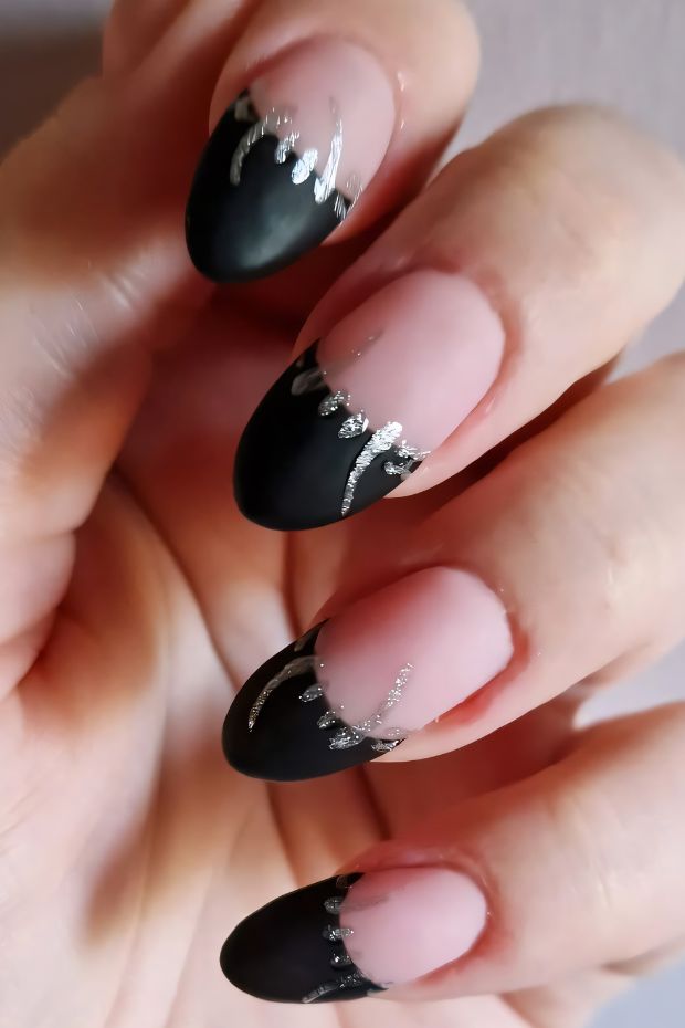 Black nail art design with silver accents perfect for stylish looks and special occasions.