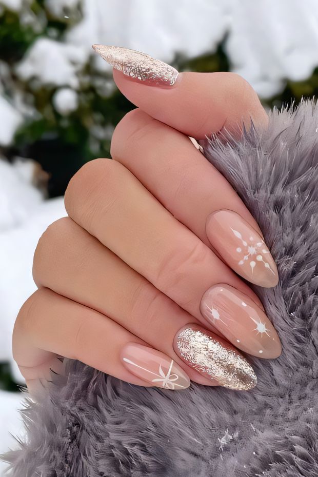 Winter nail design featuring nude base, glitter accents, and snowflake patterns on elegant almond-shaped nails.