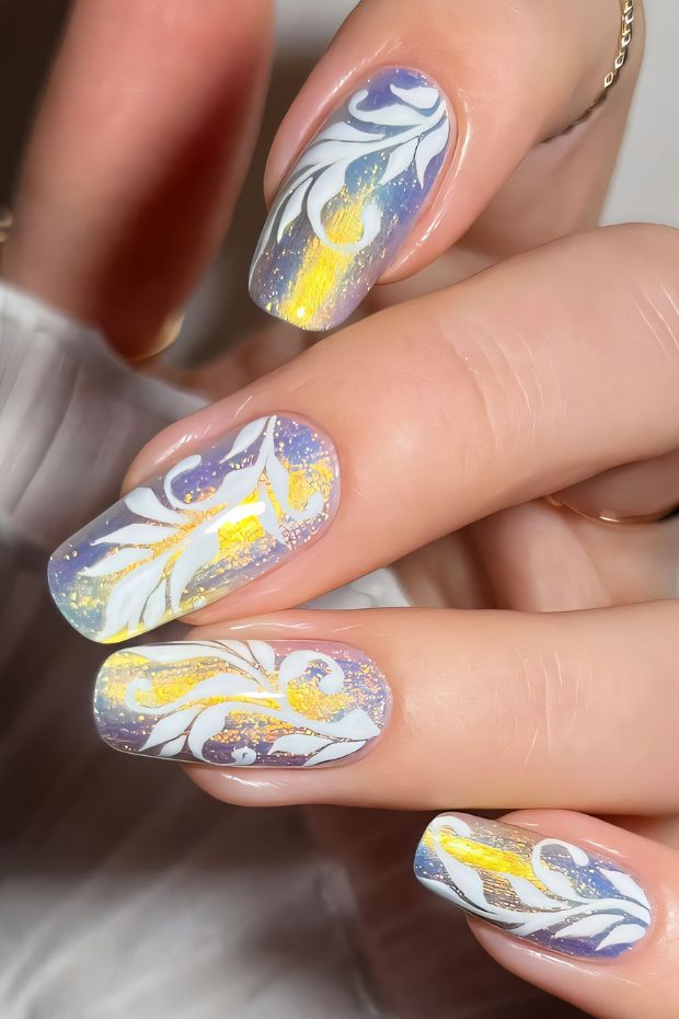 Winter-inspired nail art with blue ombre, white swirls, and gold accents for a seasonal look.