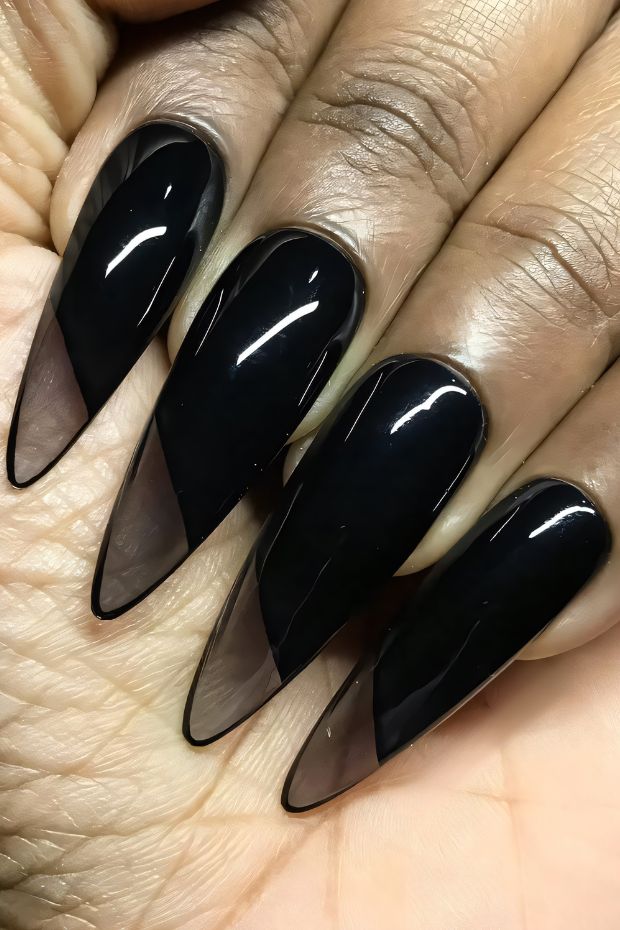 Chic black stiletto nails with a glossy finish and a stylish ombre effect for a trendy look.