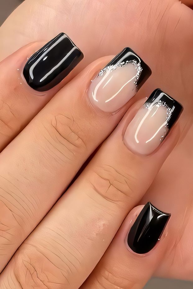 Elegant black and nude nail design with silver accents and stylish tips for a trendy look.