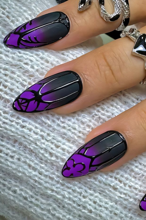 Black and purple floral nail design with glossy finish and intricate patterns for a bold style.