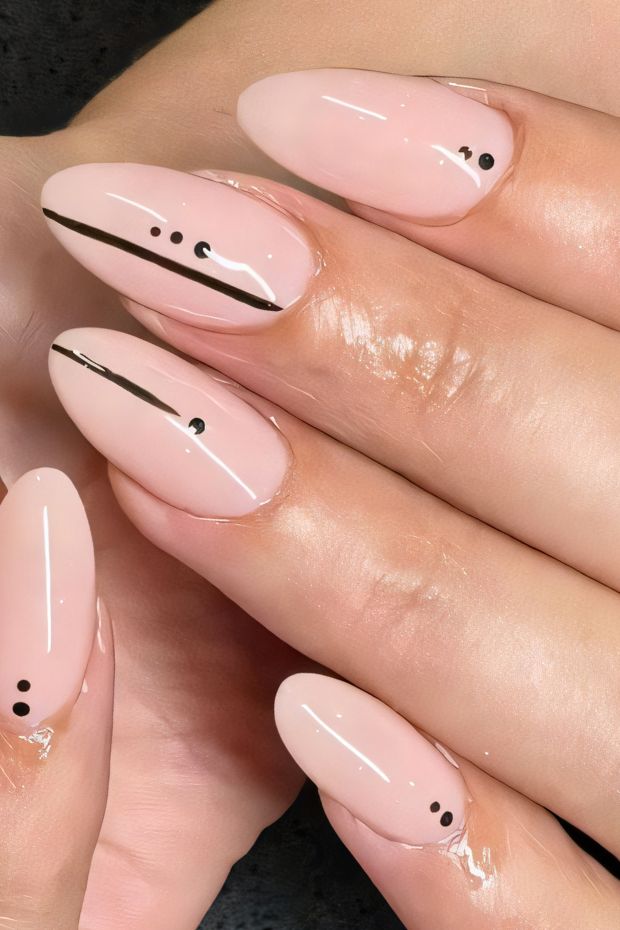 Minimalist nude nails with black line and dot accents, perfect for chic and modern nail art designs.