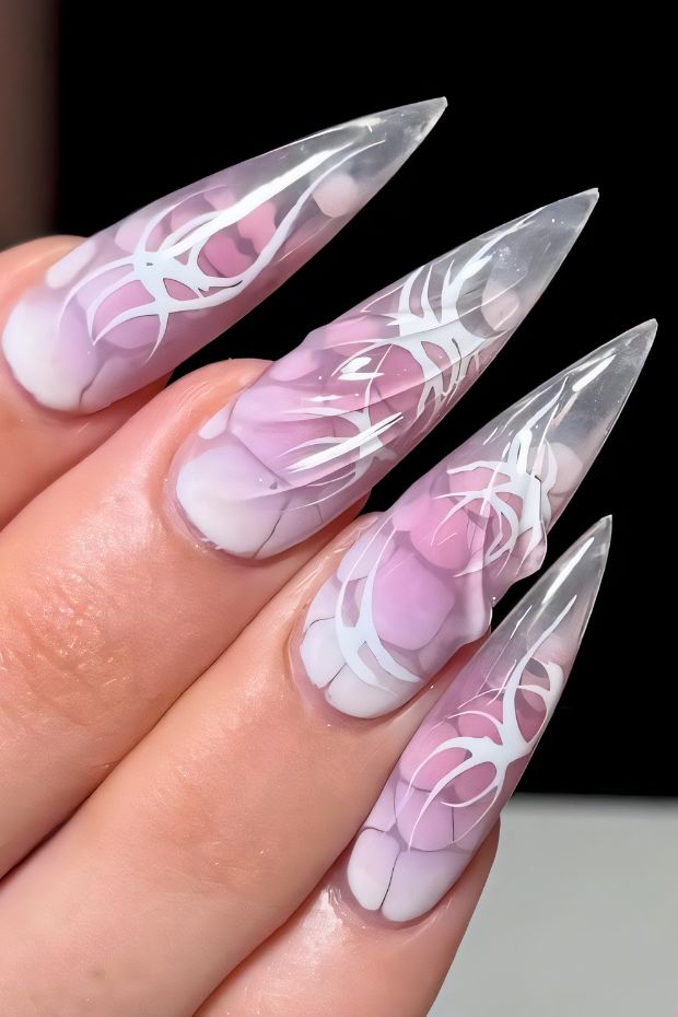 Stiletto nails featuring a pink and white abstract design on a clear base for a chic look.
