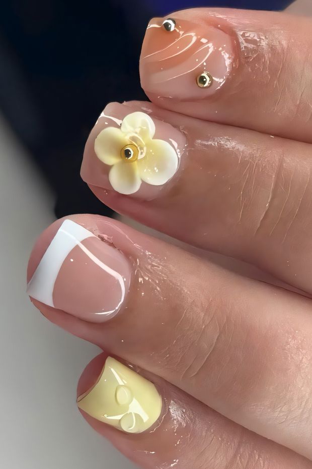 Chic short nail art with floral accents, pastel colors, and elegant designs including patterns and embellishments.