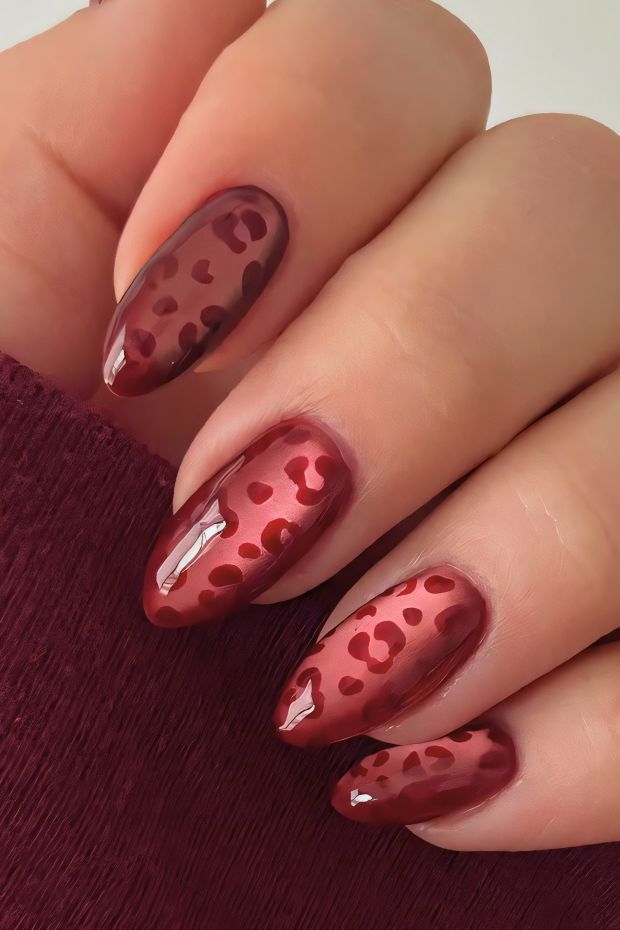 Stylish red nail design with heart patterns and glossy finish for a chic look.