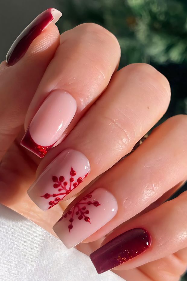 Elegant red and nude nail art featuring floral designs with glossy finish and square-shaped nails.