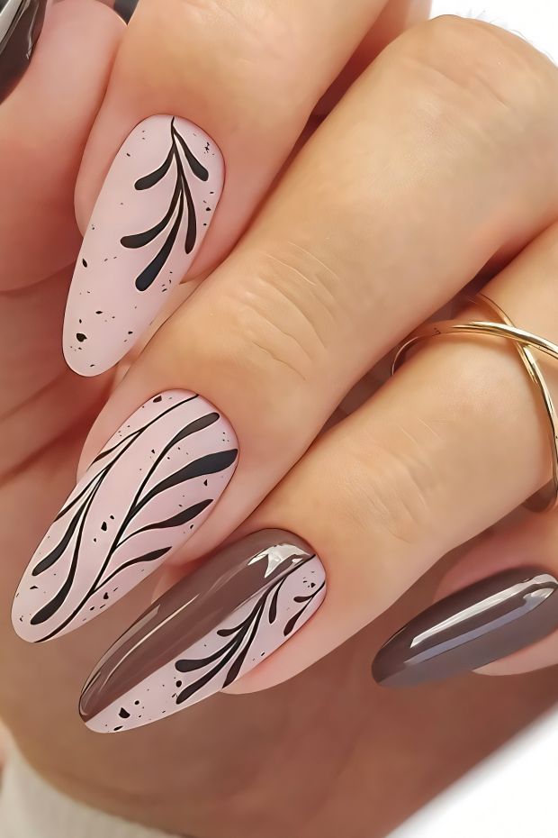 Chic brown nails with floral designs in nude and black artistic patterns, perfect for stylish nail art.