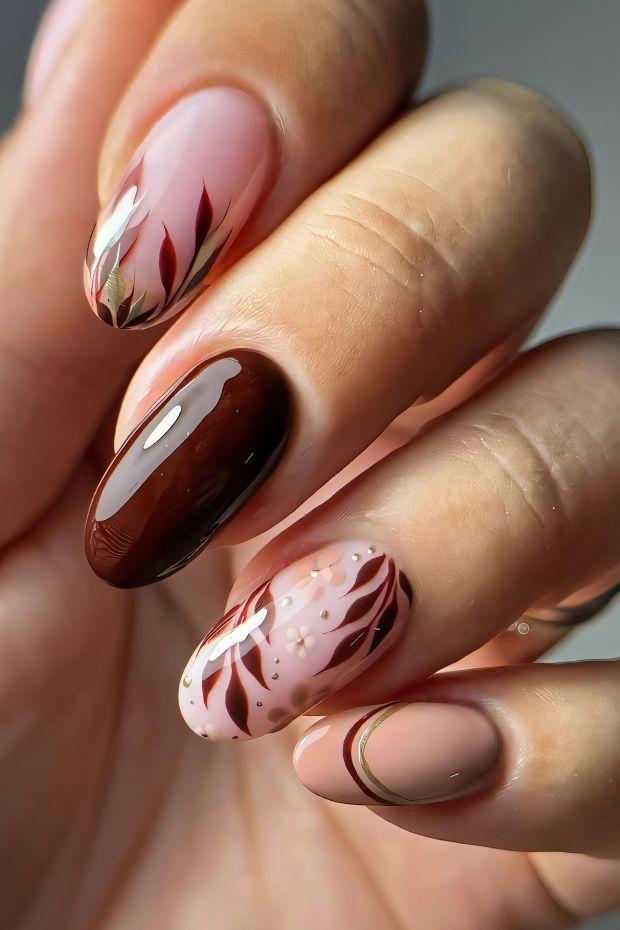 Elegant brown nails with floral designs and varied finishes in a trendy nail art style.