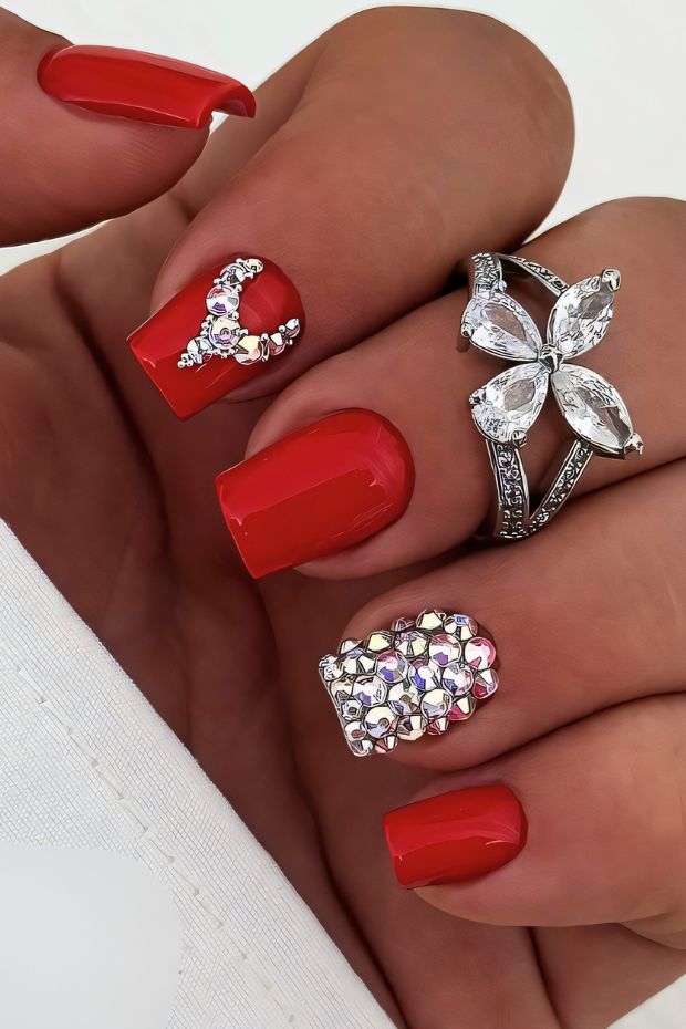 Glamorous red nails with rhinestone designs, perfect for special occasions and stylish looks.