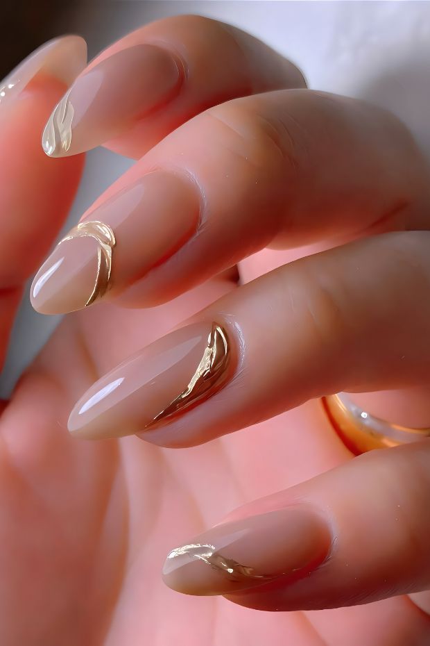 Nude nail design with gold accents, featuring a stylish and chic look perfect for elegant occasions.