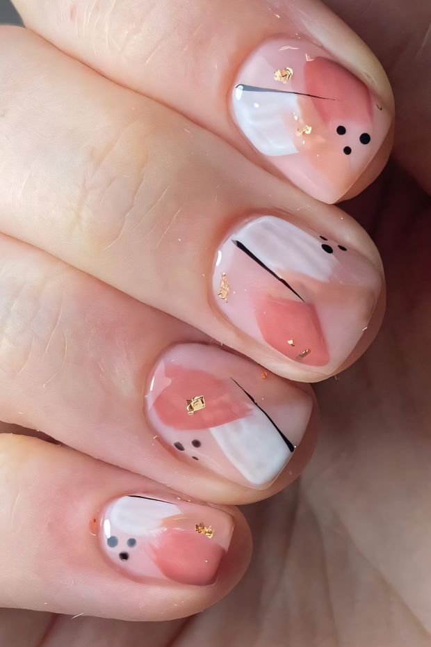 Trendy short nails with pink and white design, black lines, and gold foil accents for a modern look.