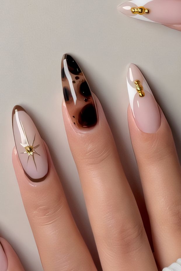 Stylish brown nails featuring glossy finishes, artistic patterns, and gold embellishments for a modern nail design.