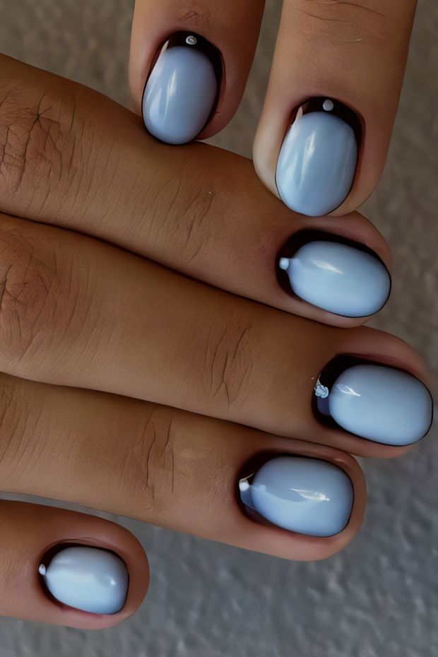 Stylish short nails featuring a blue and black design with elegant accents for a trendy look.