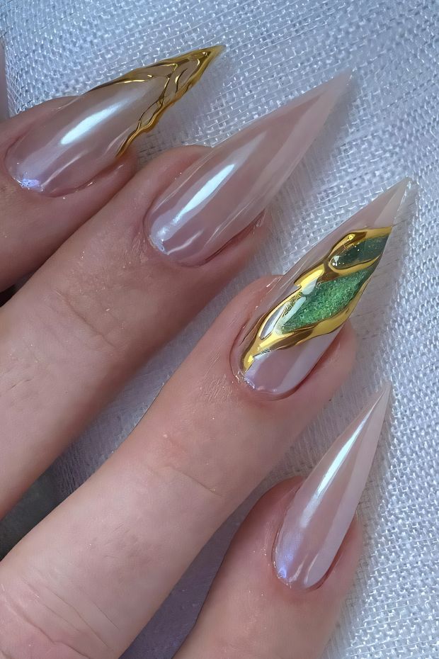 Elegant stiletto nails with gold accents and green details, glossy finish creating a chic and artistic look.