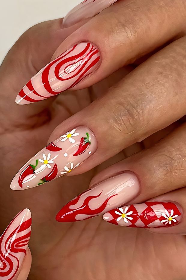 Red nail art featuring flame patterns and floral designs on stylishly shaped nails.