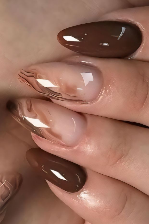 Elegant brown nails with a glossy finish featuring a gradient design and pointed tips for a chic look.