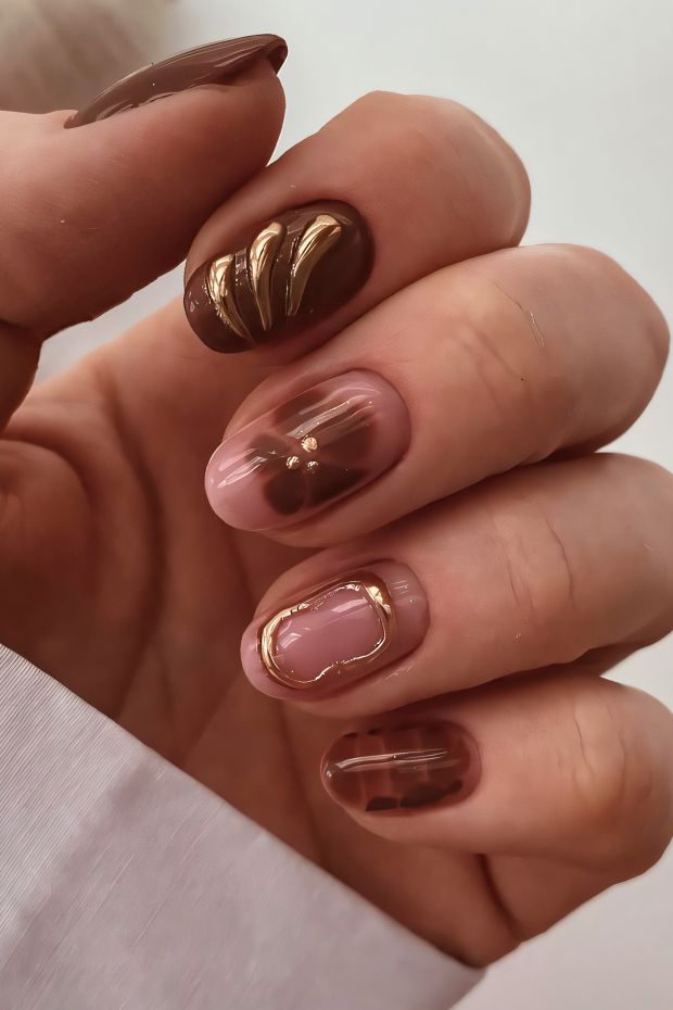 Brown nails design featuring gold accents and intricate patterns for a chic and elegant look.