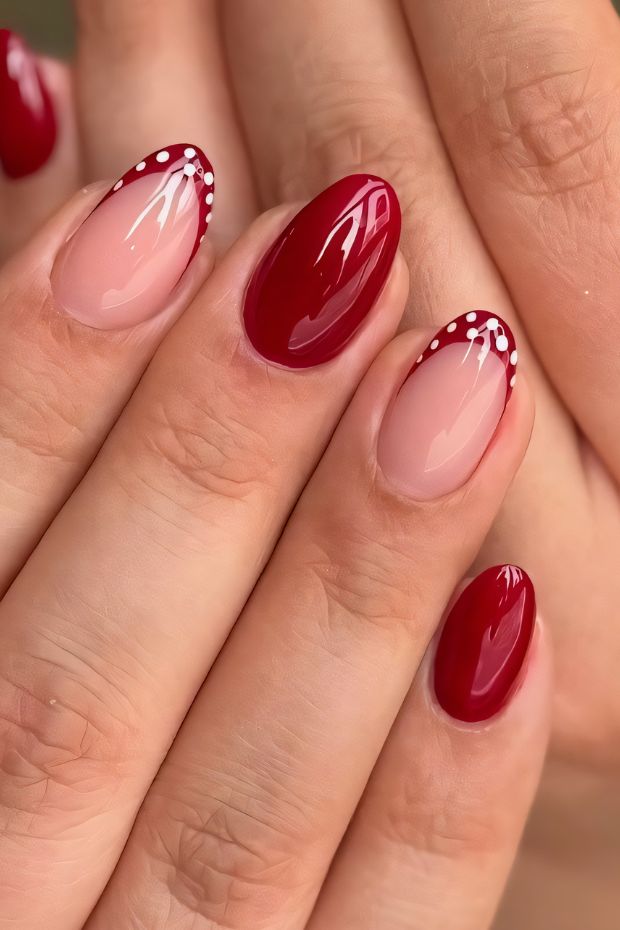 Chic red nail art design with polka dots on a nude nail base, showcasing elegance and style.